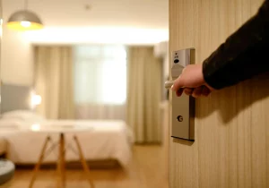 Eine Person öffnet die Tür zu einem Hotelzimmer in einer eleganten Hoteileinrichtung