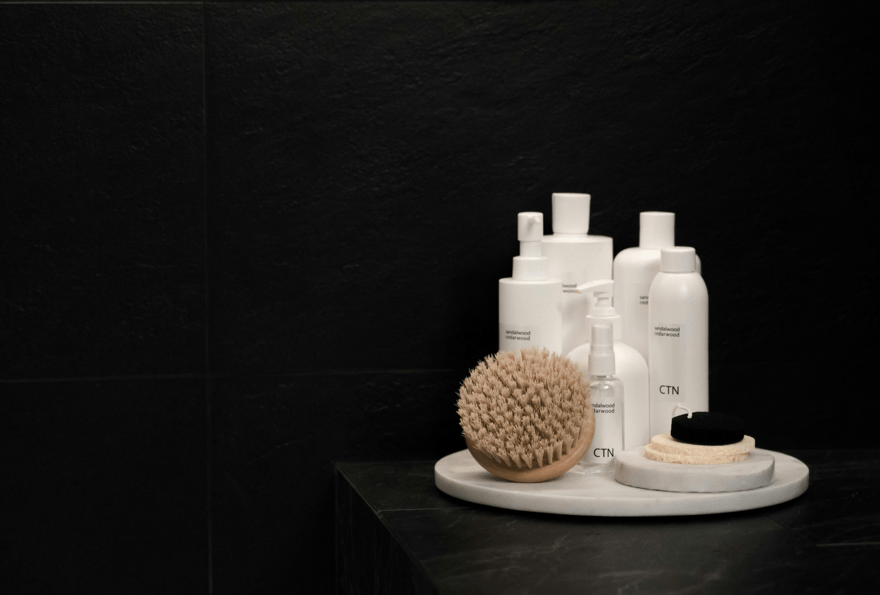 Schwarzes Badezimmer mit einem weißen Handtuch und einer Bürste, ideal für Hotel Kosmetik.